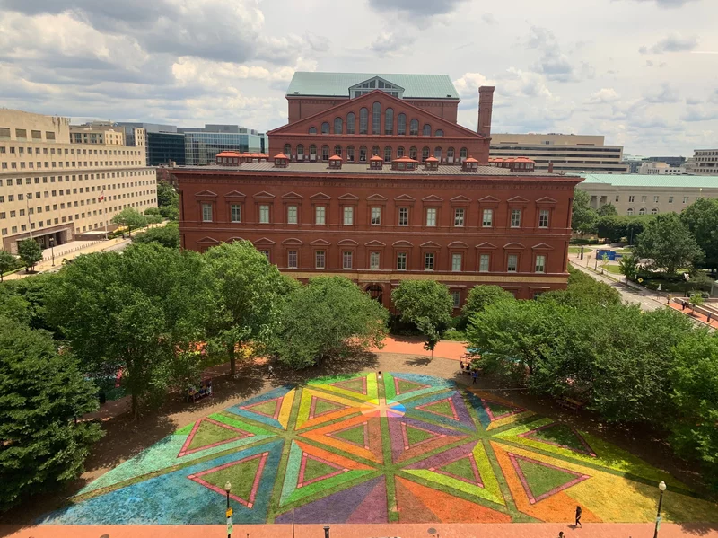 An enormous rainbow mural graces The National Building Museum lawn during Pride Month